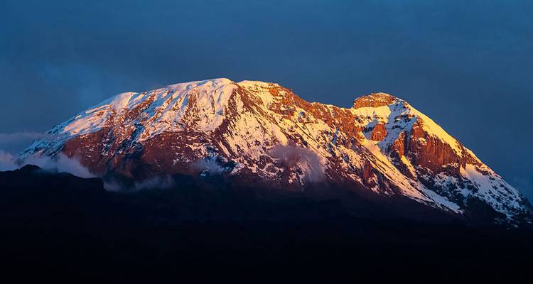 Beautiful snowy mountain peak with a brilliant sunrise glow.