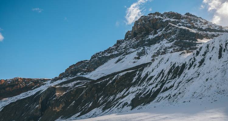 Montagne enneigée sous un ciel lumineux et dégagé.