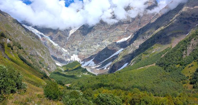 Paisaje montañoso con nubes descendiendo sobre los picos.