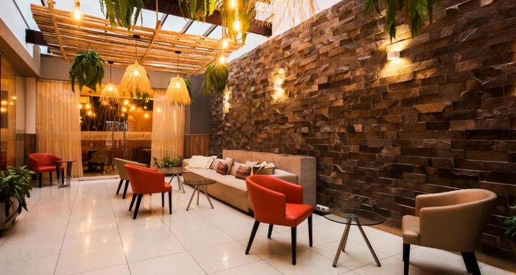 Espace lounge élégant avec des chaises colorées, des tables basses et un éclairage chaleureux.