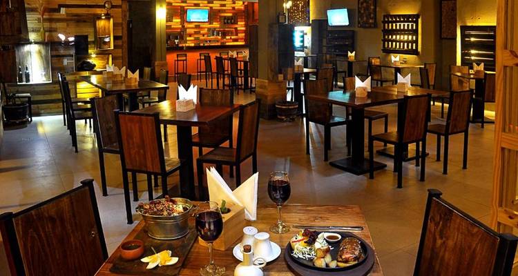 Intérieur de restaurant avec une variété d'arrangements de sièges et un éclairage tamisé.