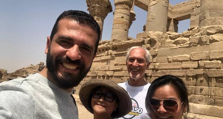 Selfie frente a ruinas antiguas, día soleado.