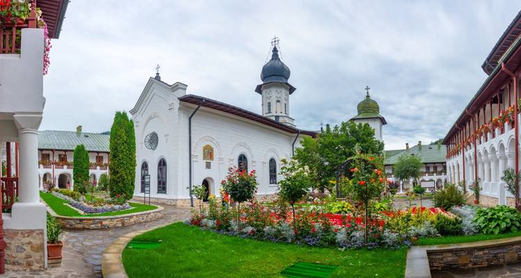 Église ornée entourée de jardins avec des fleurs colorées.