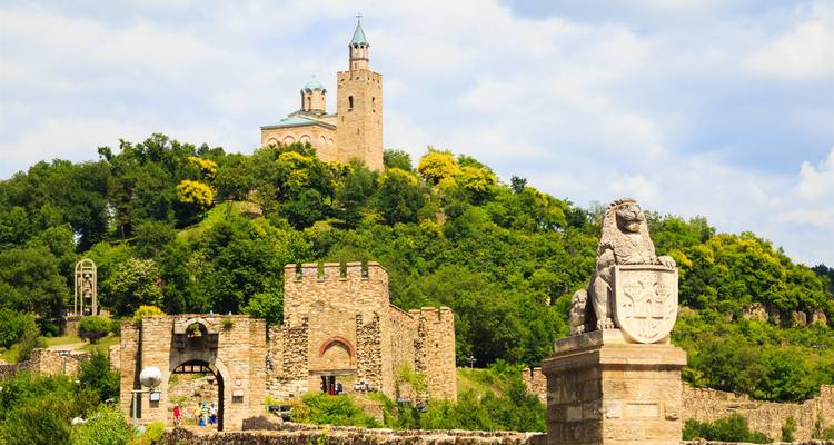 Forteresse de pierre avec de la verdure et une statue de lion.