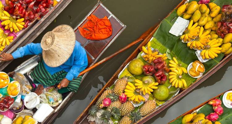 Crowded floating market with fresh produce being sold from boats.