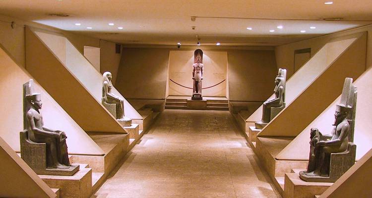 Interior de un museo con estatuas antiguas alineadas en corredores.