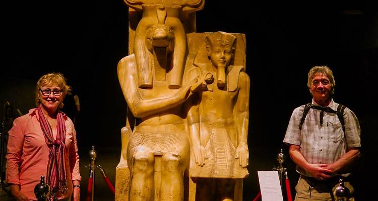 Dos turistas posando junto a estatuas del antiguo Egipto.