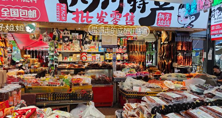 Colourful Chinese snack stall packed with dried goods, sweets and hanging sausages beneath bright signage.