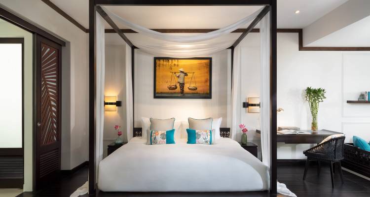 Habitación de hotel elegante con cama con dosel de cuatro postes, arte moderno y decoración elegante con iluminación suave.
