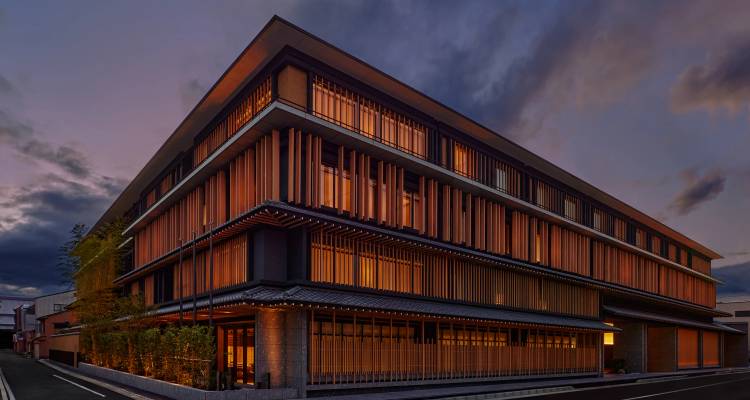 Edificio de hotel contemporáneo de varios pisos iluminado al atardecer