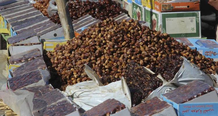Puesto de mercado con varios tipos de dátiles en exhibición.