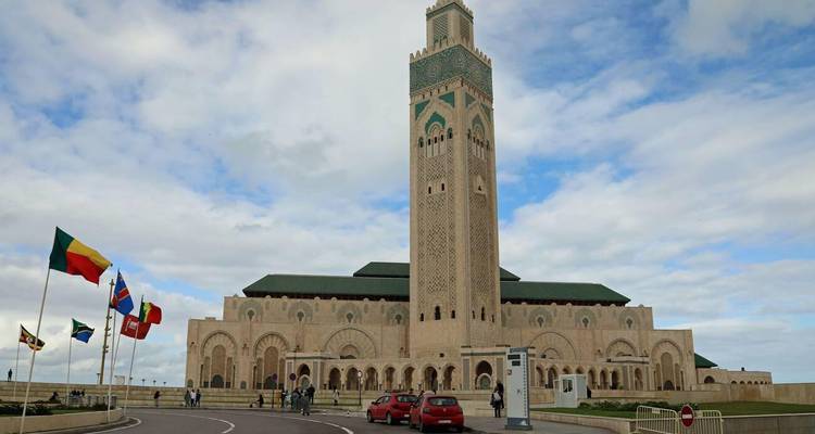 Vista impresionante de la Mezquita Hassan II desde el exterior con algunas personas visibles.