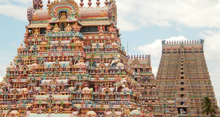Ornate Hindu temple with colorful sculptures and tall gopurams.