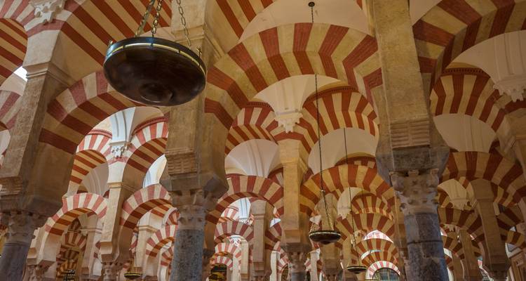 Historische moskee interieur met rood en wit gestreepte bogen.