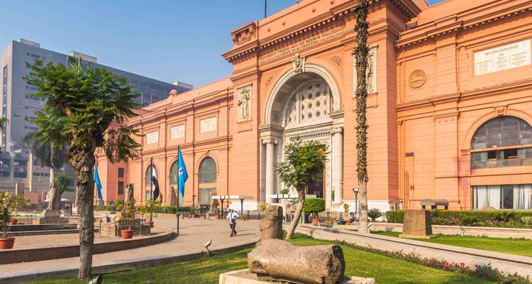 Historical museum with people walking in front, Egyptian architecture.