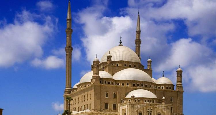 Iconic mosque with large domes under a clear blue sky.