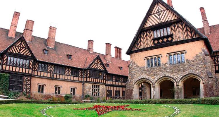 Tudor-stijl landhuis met gedessineerde houten gevel, gewelfde veranda en verzorgd gazon.
