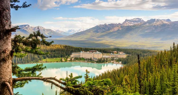 Grand alpine lodge overlooks the emerald waters of Lake Louise amid towering peaks.