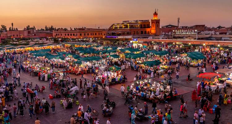 The bustling Jemaa el-Fnaa square in Marrakesh comes alive with food stalls and crowds at sunset.