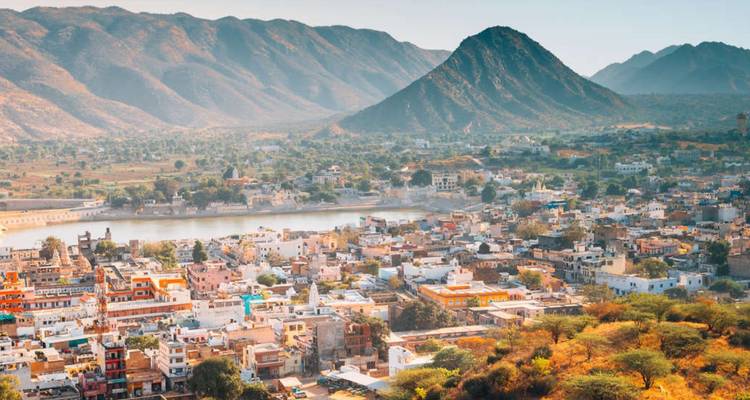 Luftpanorama der Stadt Pushkar, eingebettet zwischen trockenen Hügeln und einem zentralen See.