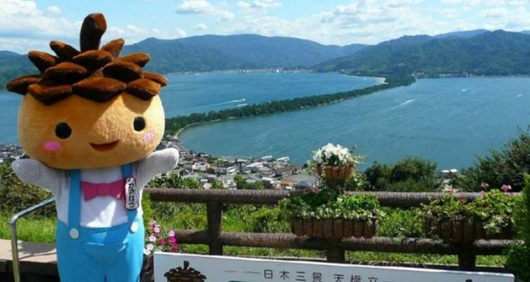Personnage mascotte en costume posant devant un paysage panoramique de baie et de banc de sable.