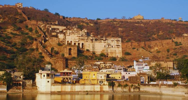 Historische Festungs- und Palastanlage, die sich über braune Hügel oberhalb der Seestadt Bundi erstreckt.