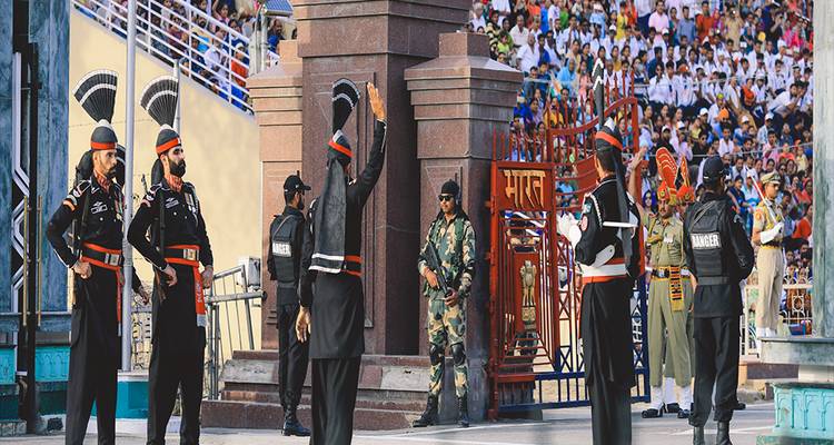 Guardias uniformados realizan la ceremonia de la frontera de Wagah ante una gran multitud que los aclama.