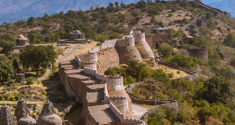 Lange defensive Steinmauern, die sich über zerklüftete Hügel einer historischen Festung winden.