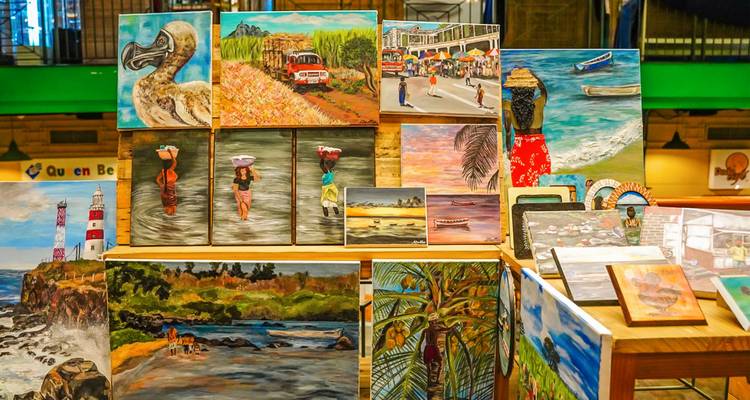 Display table full of colourful paintings and crafts featuring Mauritian themes
