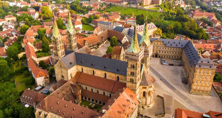 Luftaufnahme des Bamberger Domkomplexes mit Kupfertürmen, umgeben von historischen Dächern.