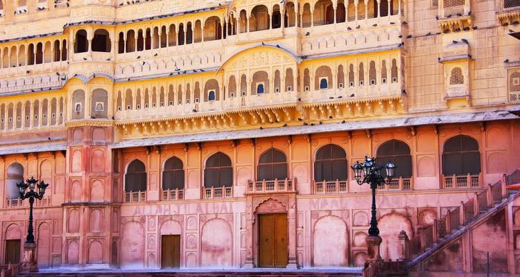 Dichtbij aanzicht van sierlijke roze zandstenen gevel van Junagarh Fort met decoratieve bogen en ramen.