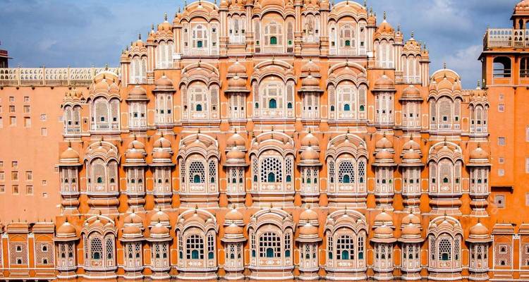 Aufwendig durchbrochene rosa Sandsteinfassade von Jaipurs Hawa Mahal mit Reihen kleiner Fenster.
