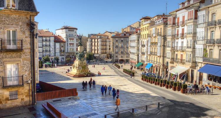 Sonniger Morgen über der Plaza de la Virgen Blanca in Vitoria-Gasteiz, umgeben von farbenfrohen baskischen Gebäuden