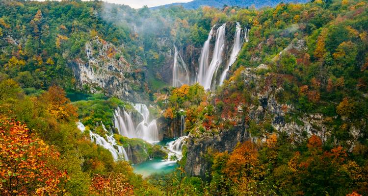 Spectacular multi-tiered waterfalls tumble through autumn foliage in Plitvice Lakes National Park.