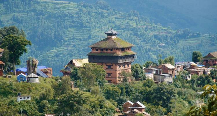 Historische rode bakstenen Nuwakot Palace toren die uittorent boven groene beboste heuvels