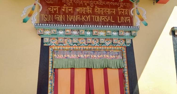 Decorative monastery doorway with ornate Tibetan script and colorful trim.