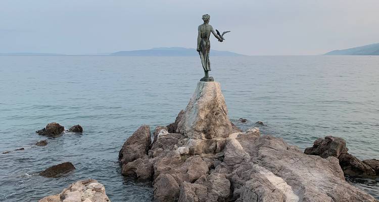 La statue de la Fille de Bronze avec une Mouette, perchée sur la jetée rocheuse, contemple la mer Adriatique calme à Opatija.