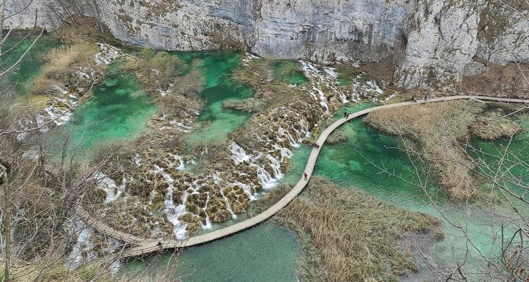 Vue surélevée des cascades émeraude et de la passerelle en bois sinuant à travers le parc national des lacs de Plitvice.