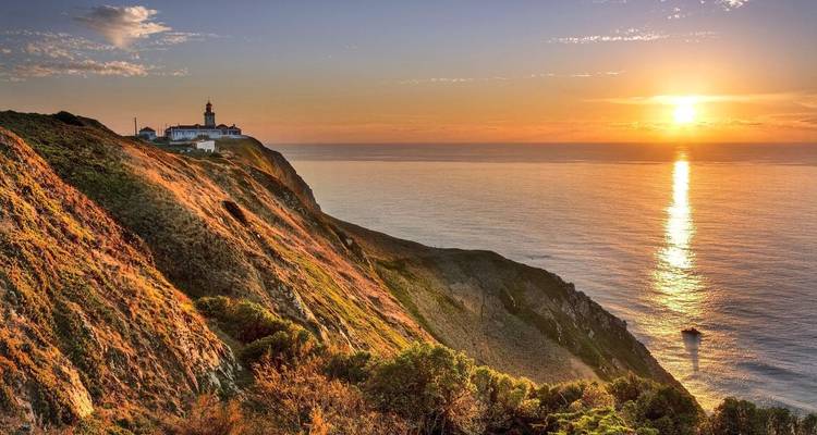 Goldener Sonnenuntergang über dem Leuchtturm Cabo da Roca und steilen Klippen, die auf den Atlantik treffen.