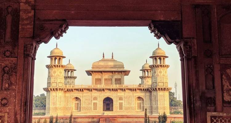 La Tumba de Itimad-ud-Daulah enmarcada por un arco ornamentado de arenisca.