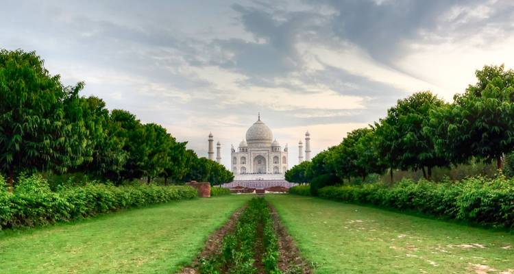 Larga avenida de jardín que conduce al icónico Taj Mahal de mármol blanco.