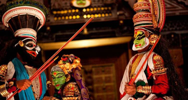Lebendige Kathakali-Darsteller in bunten Masken und prächtigen Kostümen spielen eine dramatische Szene auf der Bühne.