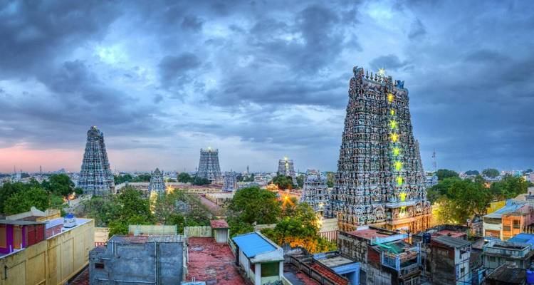 Panoramische Stadtansicht von Madurai mit beleuchteten Meenakshi-Tempel-Türmen unter einem stimmungsvollen Zwielicht-Himmel.