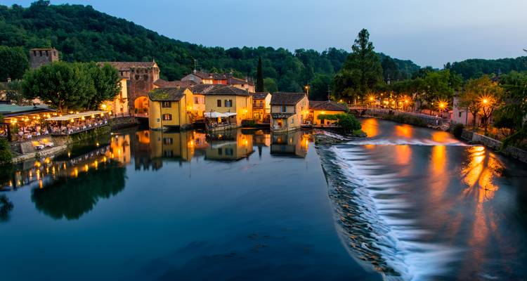 Les lumières du soir scintillent sur l'eau au pittoresque village de Borghetto sul Mincio et son déversoir sur la rivière.
