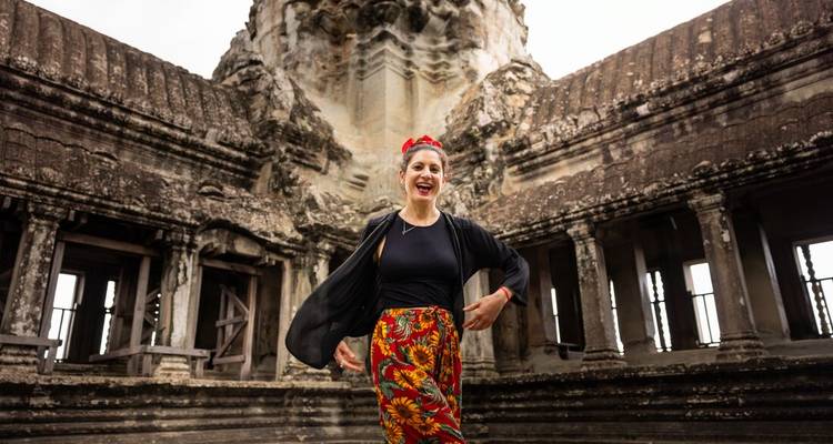 Jeune femme posant de manière ludique dans un ancien couloir de pierre d'Angkor Vat