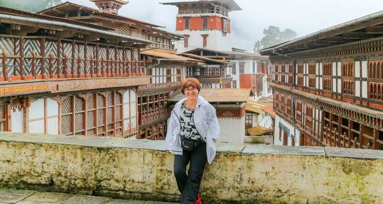 Une voyageuse pose devant l'architecture en bois complexe du Punakha Dzong.