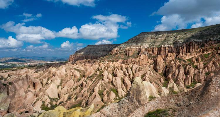Eroded pink rock spires and ridges under blue sky in Cappadocia’s Red Valley