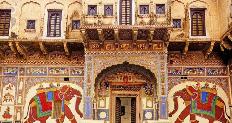 Vibrantly painted frescoes of elephants adorn an ornate haveli façade in Shekhawati.