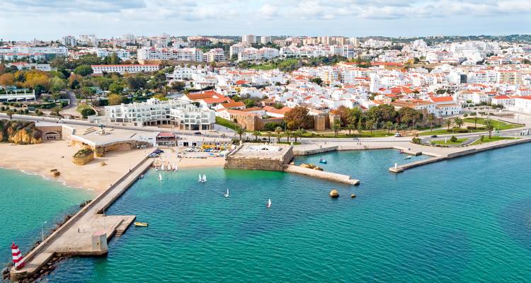 Vista aérea de Lagos mostrando el pueblo encalado, la playa de arena y las aguas turquesas del Algarve