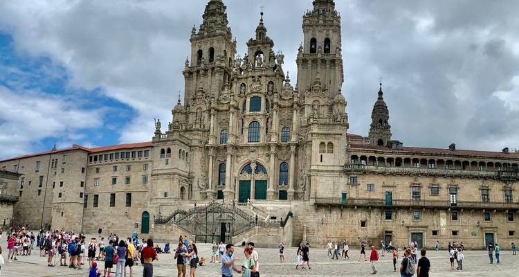 Menschenmengen versammeln sich vor der prächtigen zweitürmigen Kathedrale von Santiago de Compostela.